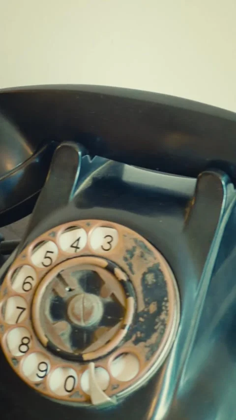 Cinematic vertical close-up of old antique black rotary dial telephone Vidéo 345501151
