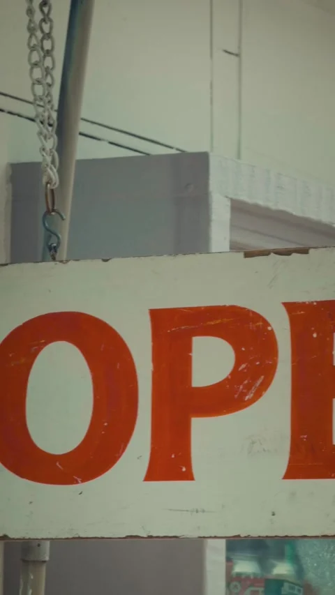 Cinematic vertical close-up pan of a weathered vintage open sign hanging Stock Footage 345514176