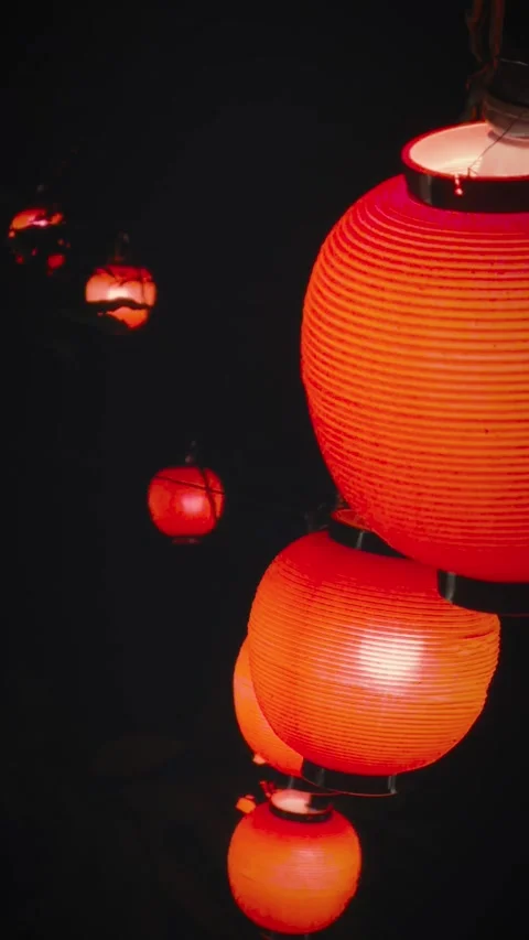 Cinematic vertical close-up shot of glowing red Japanese paper lanterns Vidéo 345423852