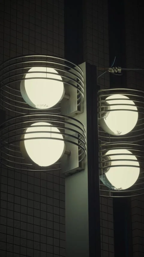 Cinematic vertical close-up shot of glowing retro modern outdoor lamps Vidéo 345488928