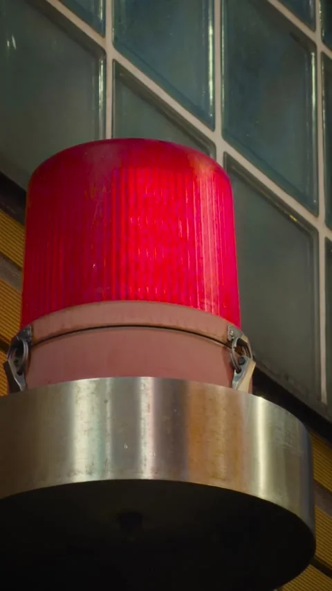 Cinematic vertical close-up of a stationary red security beacon Vidéo 345700554