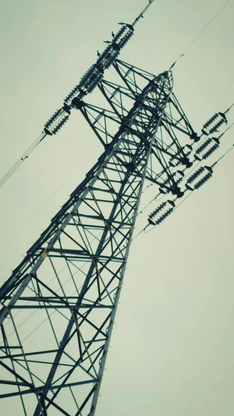 Cinematic vertical low angle view of large steel high voltage tower Stock Footage 345699857