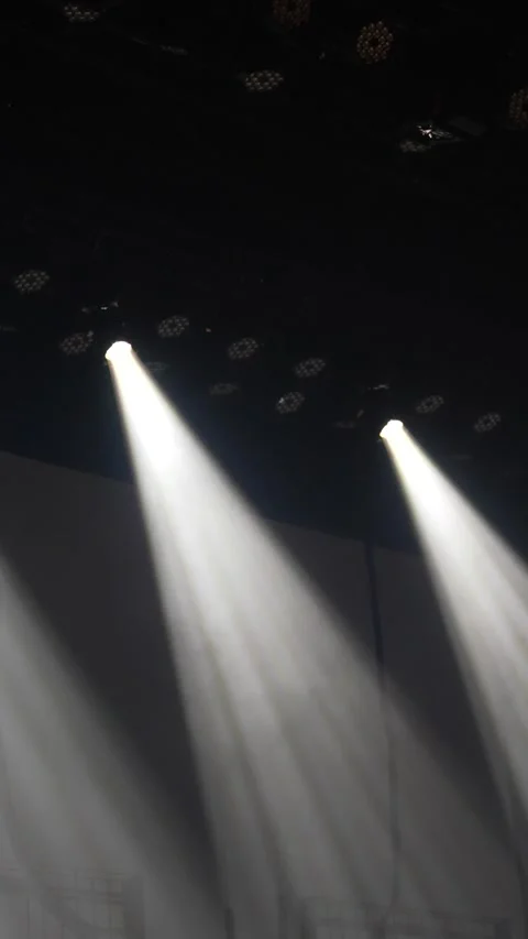 Cinematic vertical pan of bright white stage spotlights beaming Vidéo 345704605