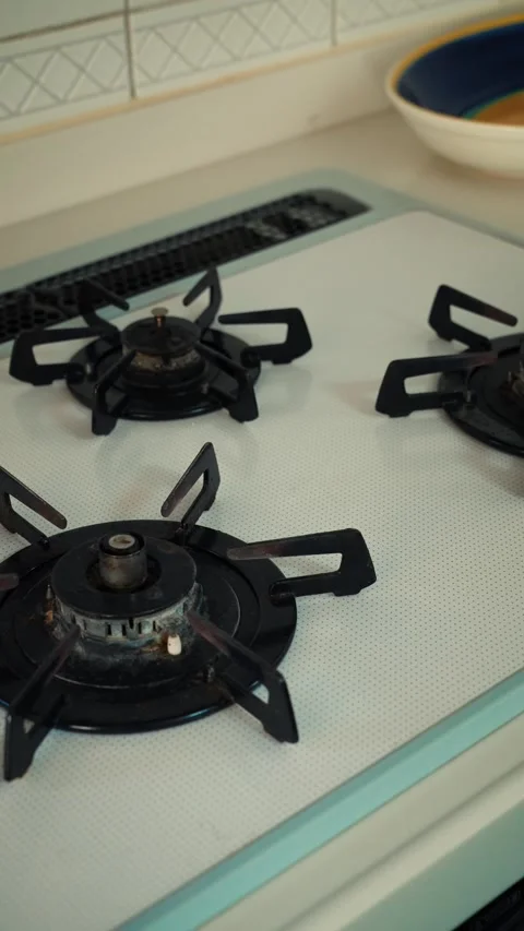 Cinematic vertical pan of clean modern white gas stove with black parts Vidéo 345700319
