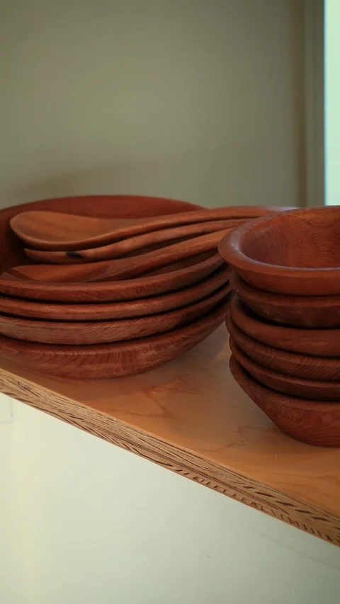 Cinematic vertical pan of stacked rustic wooden bowls and utensils Stock Footage 345700364