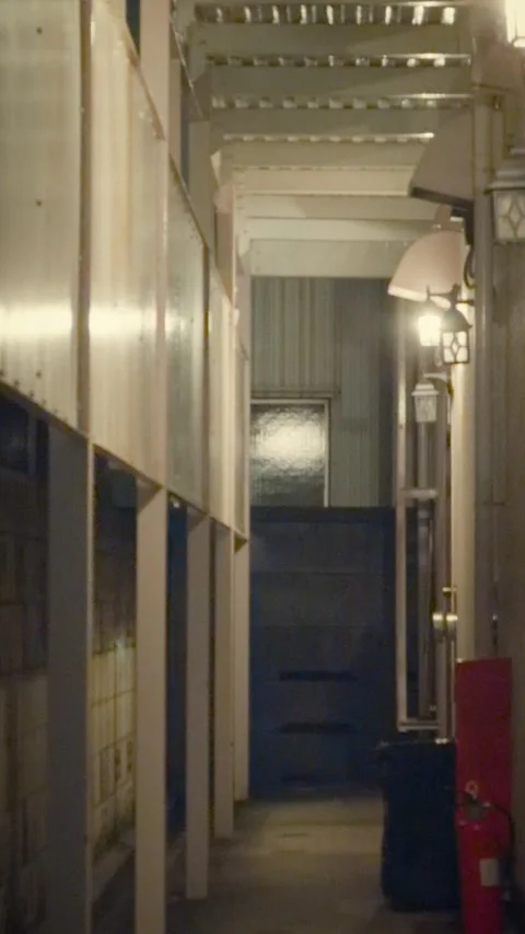 Cinematic vertical shot of a narrow dim alleyway or building passage Stock Footage 345489334