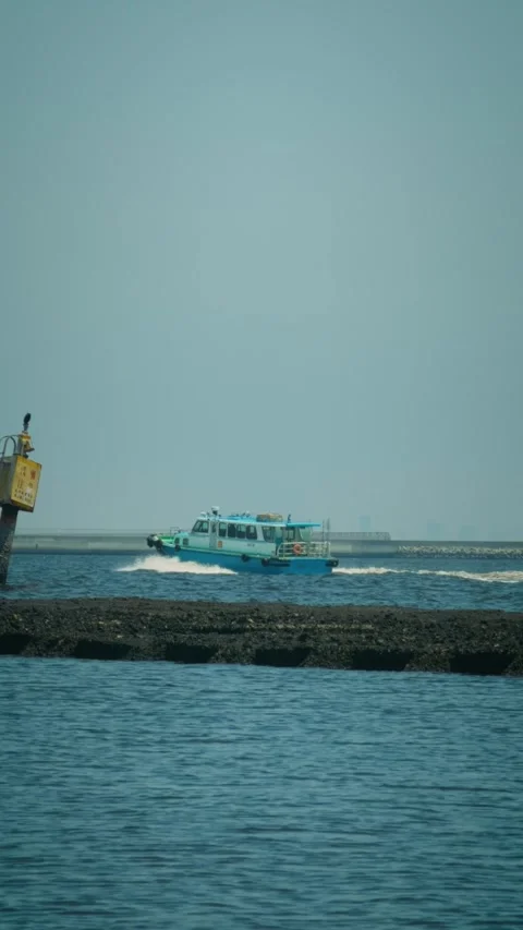 Cinematic vertical shot of a small blue passenger boat speeding across Stock Footage 345457843