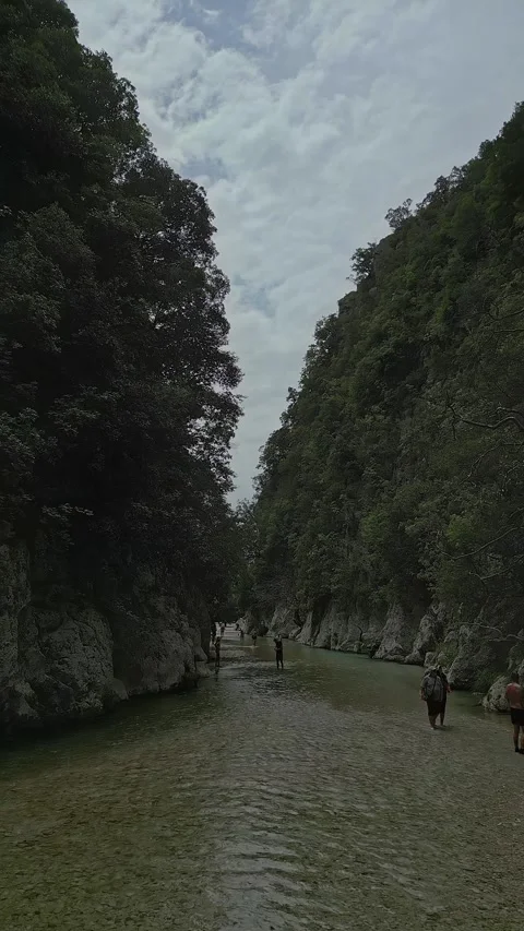 Cinematic vertical video of people exploring the crystal clear Acheron sprin Stock-Footage 347441641