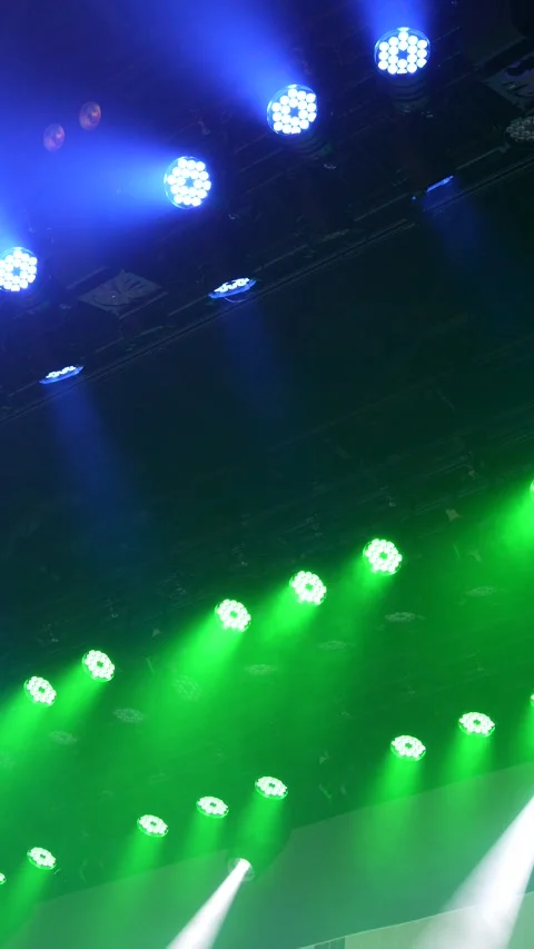 Cinematic vertical view of bright blue and green LED stage lights Vidéo 345704302