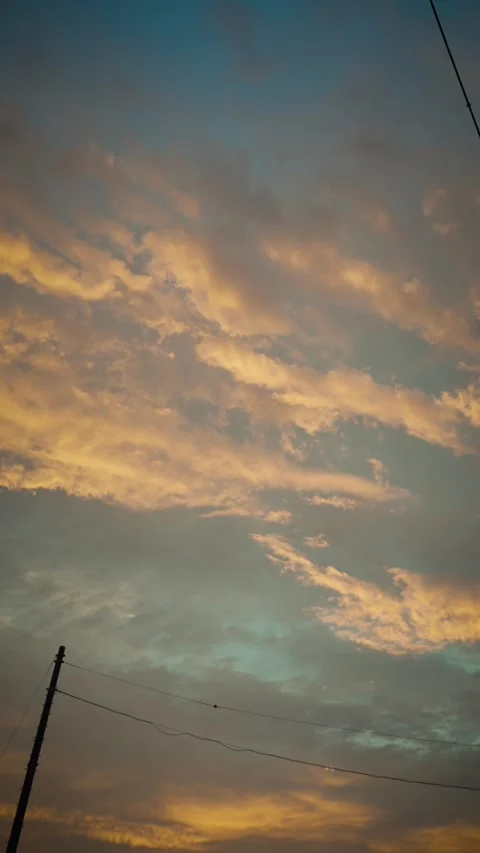 Cinematic vertical view of dramatic golden sunset sky with clouds Vidéo 345699515