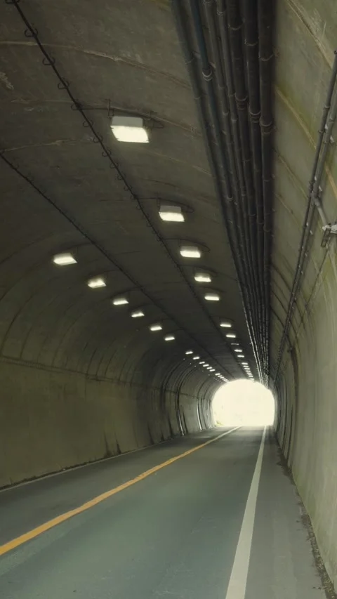 Cinematic vertical view from inside a curved concrete highway tunnel Vidéo 345698759