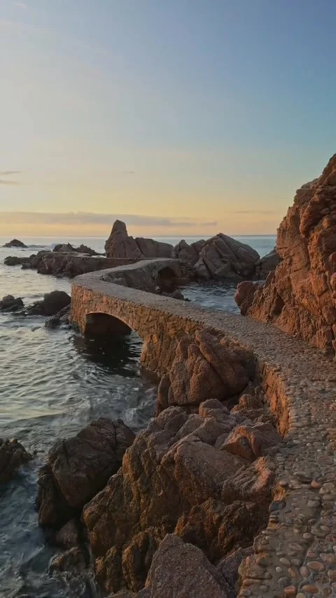 Cinematic Video of Stone Bridge on Costa Brava Coast at Sunset with Wave Sounds Stock Footage 330093014