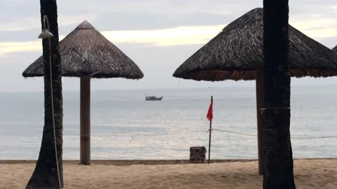 Cinematic view at the beach with coconut tree branch, beach huts and boat. Stock Footage 148301308