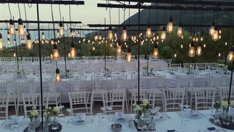 Cinematic view of luxury wedding reception with edison bulbs and sea view Stock Footage 346568679