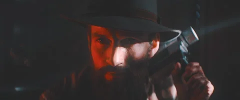 Cinematic view of man in red light holding vintage camera Stock Footage 203564211