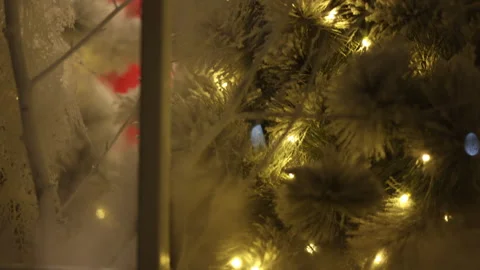 Cinematic view outside window evening scene with glowing Christmas tree lights Video stock 324414868