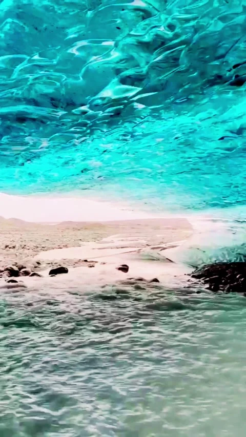 Cinematic view of river flowing through blue ice cave with glowing transluc.. Stock Footage 331404234