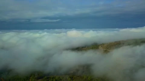 Cinematic view tilting down from clouds to foggy forest landscape Stock-Footage 345953780
