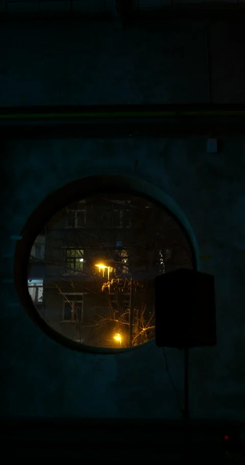Cinematic winter scene  round window, circular frame  street lamp stands. Video stock 327843395