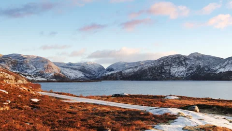 Cinematic winter sunset timelapse over lake and snowy mountains in Norway Video stock 327555350