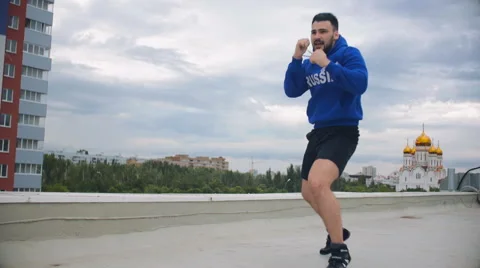 Cinematic Young Man Shadow Boxing On The Roof Stock Footage 64930149