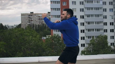 Cinematic Young Man Shadow Boxing On The Roof Stock Footage 64930186