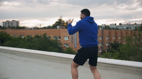 Cinematic Young Man Shadow Boxing On The Roof Stock Footage 64930232