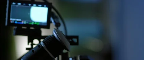 Cinematographer (camera operator) working with a cinema camera at night Stock Footage 100156846