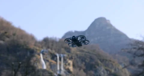 Cinewhoop Style Drone Hovering in Front of Mountain Ridge Stock Footage 343927713