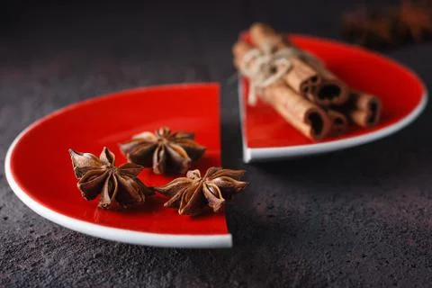Cinnamon and anise on a red split plate. Stock Photos