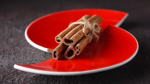 Cinnamon and anise on a red split plate. Stock Photos