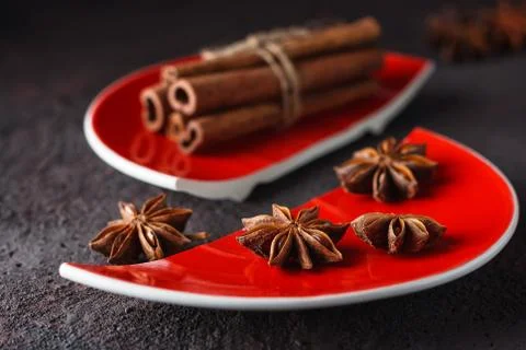 Cinnamon and anise on a red split plate. Stock Photos