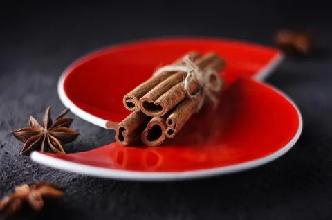 Cinnamon and anise on a red split plate. Stock Photos