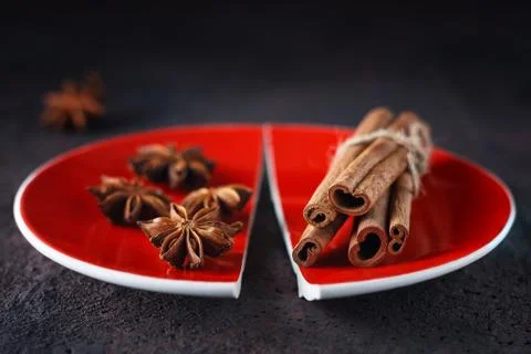 Cinnamon and anise on a red split plate. Foto stock