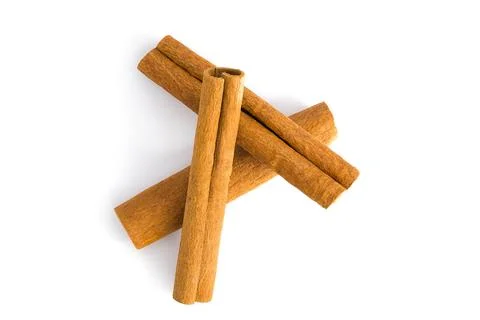 Cinnamon bark pieces spread across a white surface, highlighting their fibr.. Stock Photos