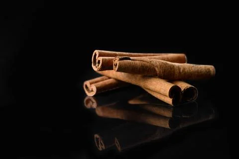 Cinnamon on black mirror background Stock Photos