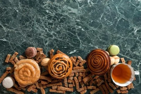 Cinnamon bun, cookie, walnut, rye crackers, macarons view from above on marble Stock Photos