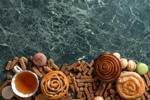 Cinnamon bun, cookie, walnut, rye crackers, macarons view from above on marble Stock Photos