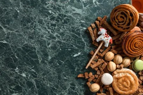 Cinnamon bun, cookie, walnut, rye crackers, macarons view from above on marble Stock Photos