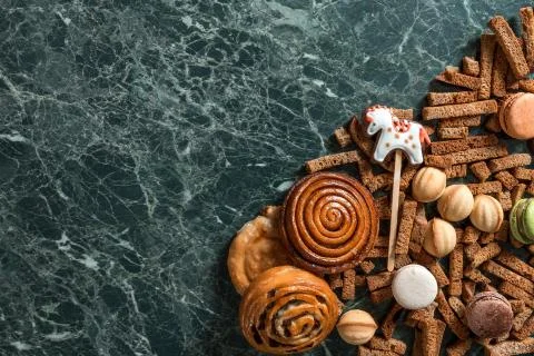 Cinnamon bun, cookie, walnut, rye crackers, macarons view from above on marble Stock Photos