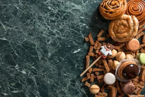 Cinnamon bun, cookie, walnut, rye crackers, macarons view from above on marble Foto stock