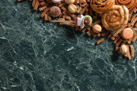 Cinnamon bun, cookie, walnut, rye crackers, macarons view from above on marble Stock Photos