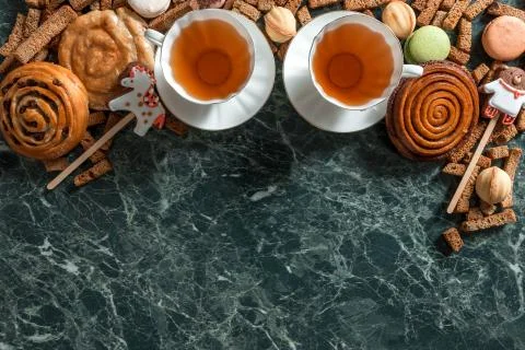 Cinnamon bun, cookie, walnut, rye crackers, macarons view from above on marble Stock Photos