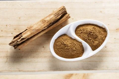 Cinnamon chips and powder on rustic wood Stock Photos