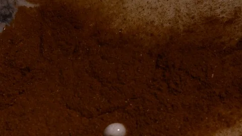 Cinnamon powder and bubbles. Close-up of mixer whipping milk smoothie with Stock Footage 84023331