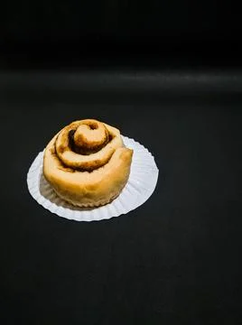 Cinnamon roll isolated on black background Stock Photos