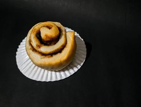 Cinnamon roll isolated on black background Stock Photos