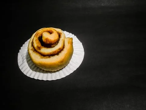 Cinnamon roll isolated on black background Stock Photos