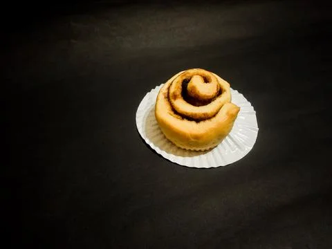 Cinnamon roll isolated on black background Stock Photos