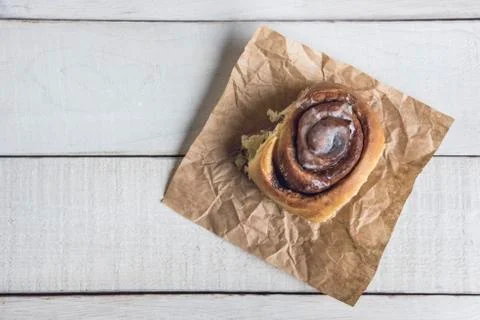 Cinnamon roll over a white rustic wooden table ready to eat. Stock Photos
